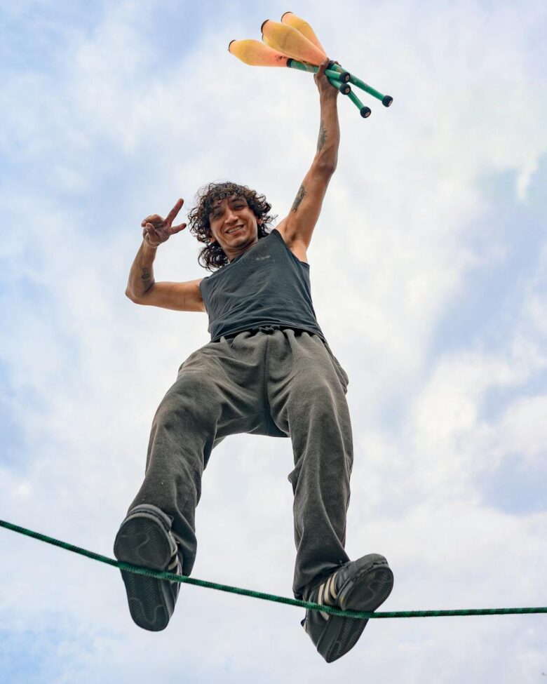dynamic slackliner performing aerial juggling skills