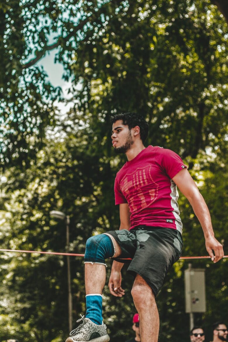 man sitting on wire by tree
